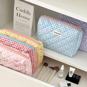 Quilted gingham cosmetic bag with bow pattern and zip closure for travel storage