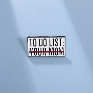 Détail d'un pin's émaillé créatif 'To Do List: Your Mom' sur un fond bleu clair épuré