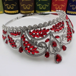 Detail of silver bridal crown featuring red teardrop stones and sparkling crystals