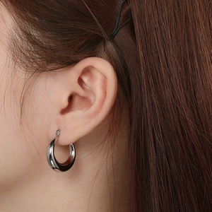 Close-up of minimalist silver hollow oval hoop earrings on model for an elegant look