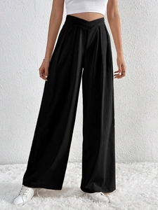 Detail of high waisted black wide leg trousers with a unique crossover V-neck waist design