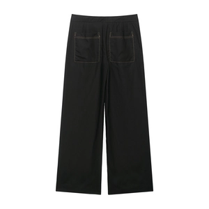 Detail of black wide-leg trousers with contrast stitching and large rear patch pockets
