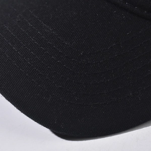Close-up of black cotton baseball cap brim with multiple parallel reinforced stitch lines