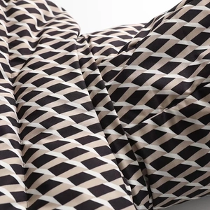 Close-up of quilted fabric with geometric diamond pattern on warm hooded ski jacket