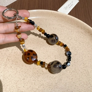 Detailed macro of vintage style leopard print beads and amber resin pendant keychain
