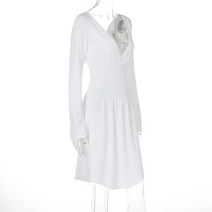 Detail of white V-neck long sleeve dress featuring high waist design and pleated A-line hem