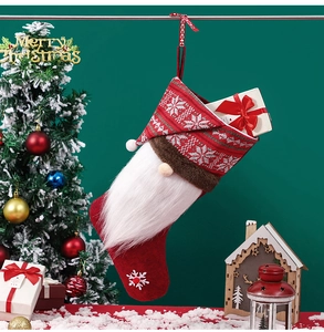 Detail of red knit Christmas stocking with snowflake pattern and gift box inside