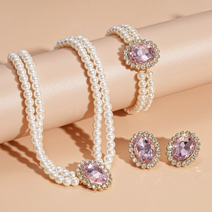 Detail of three-piece jewelry set with double-layer pearls and oval pink gemstone