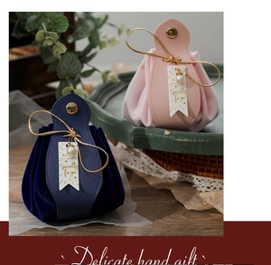 Close-up of pink and navy leather velvet candy bags with gold drawstring and pearls