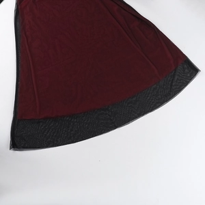 Detail of the wine red fabric and black mesh patchwork on the elegant dress hemline
