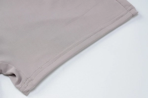 Detailed close-up of double-stitched hem and fine knit texture on purple backless jumpsuit