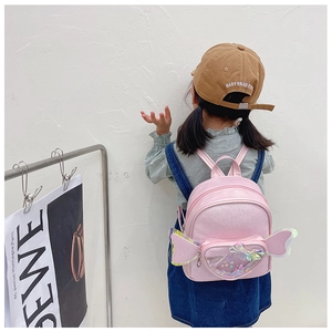 Pink sequin backpack with laser-cut wings and transparent heart glitter pocket on girl
