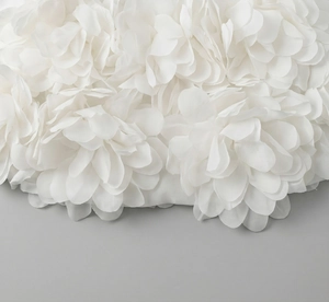 Detailed macro shot of white 3D floral petals on elegant mesh evening dress fabric