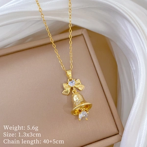 Detail of gold bow bell necklace with heart zircon on silk fabric and size parameters
