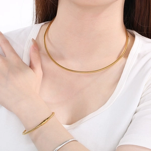 Close-up of minimalist 18K gold plated snake chain necklace and bracelet set on a model