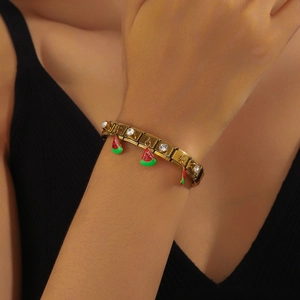 Gold chain bracelet with watermelon enamel charm and sparkling crystal on a wrist