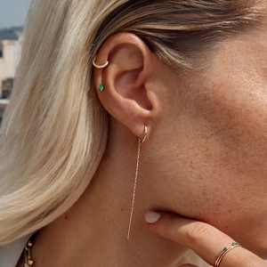 925 silver C-chain tassel earrings and gold emerald rings on a model in sunlight
