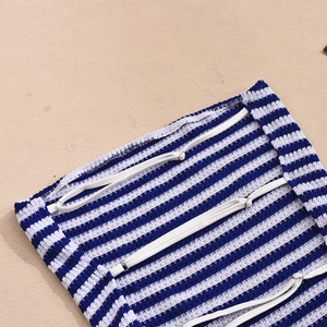 Detailed close-up of blue and white striped knit fabric with adjustable elastic white strap