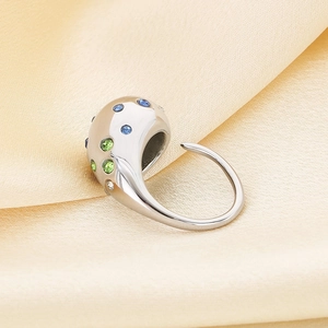 Macro detail of polished stainless steel teardrop ring with colorful cubic zirconia