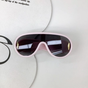 Détail de lunettes de soleil sport enfant roses avec visière violette et accents dorés