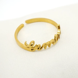 Detailed view of an adjustable gold stainless steel ring with custom Emma name engraving