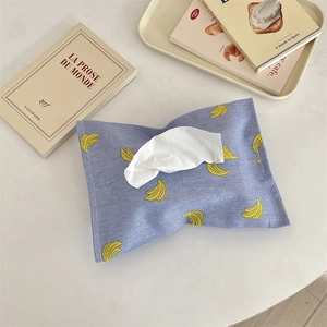 Detail view of purple fabric tissue box cover with yellow banana print in French retro style