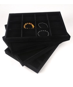 Detail view of 12-slot black velvet jewelry trays stacked for professional counter display
