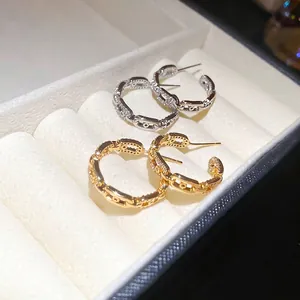 Elegant gold and silver C-shaped chain link earrings with cubic zirconia in a jewelry box