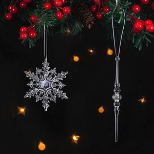 Close-up of crystal snowflake and icicle ornaments hanging on a festive pine branch