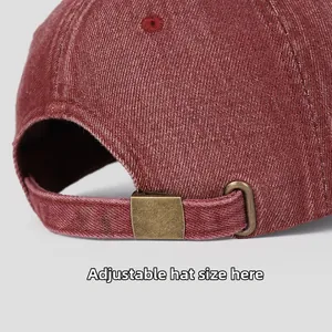 Détail de la boucle métallique réglable sur une casquette de baseball en jean rouge délavé