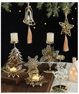 Close-up of golden Christmas candle holders with reindeer and tree shapes on snow decor