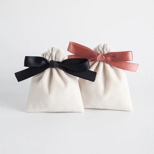 Cream velvet drawstring jewelry bags featuring black and brick red satin bow decorations
