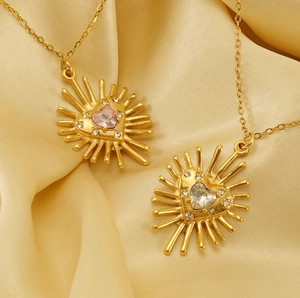 Détail d'un collier cœur en or 18k avec zircons roses et clairs sur de la soie