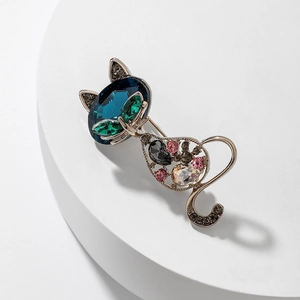 Macro shot of detailed cat brooch with dark blue rhinestone and colorful gems