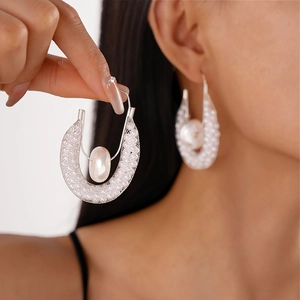 Detail of U-shaped silver mesh earrings featuring a suspended white faux pearl for women