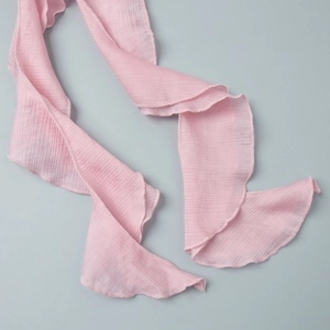Detail of pink ruffled chiffon fabric with fine hemmed edges and pleated texture