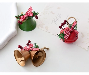 Detailed view of red, green, and gold Christmas bells with plaid bows and pine needles