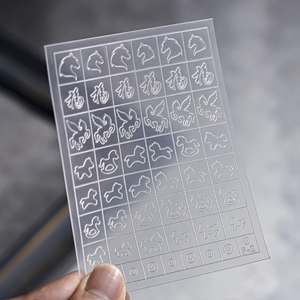 Close-up of F-2 nail art stencil sheet with horse and bow patterns for French manicure