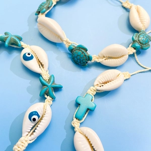 Macro shot of handmade shell jewelry with turquoise turtle beads and evil eye patterns
