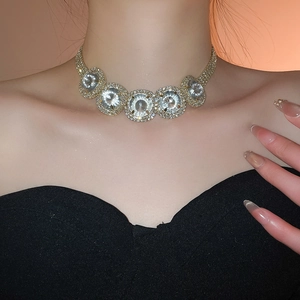 Close-up of sparkling round rhinestones on a gold necklace worn on neck