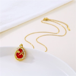 Golden necklace featuring a red teardrop pendant with zircon inlay and leaf pattern