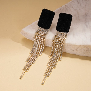 Gros plan de boucles d'oreilles rectangulaires noires avec de longs pompons en strass d'or