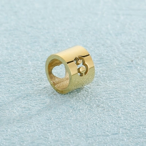 Macro shot of gold stainless steel bead with hollow heart and Roman numeral patterns