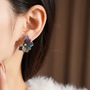 Vintage floral stud earrings with colorful zirconia stones worn on a model's ear