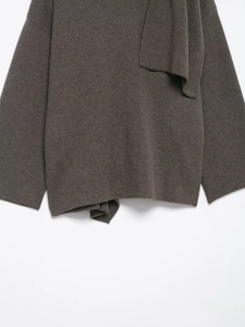 Detail of dark brown knitted poncho with elegant asymmetrical scarf collar draping