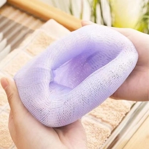 Thickened purple mesh foaming net for facial soap being held with both hands