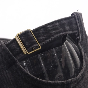 Detail of vintage bronze metal buckle and washed fabric texture on baseball cap back