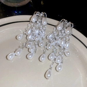 Detail of elegant silver tassel earrings with tiered white pearls and water drop charms