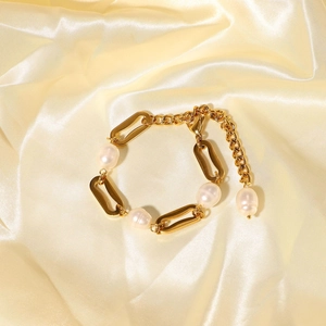 Detailed close-up of 18k gold-plated chain bracelet with white baroque pearls on yellow silk