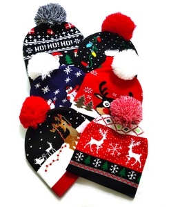 Detailed flat lay of six festive Christmas knit beanies with holiday patterns and pom-poms